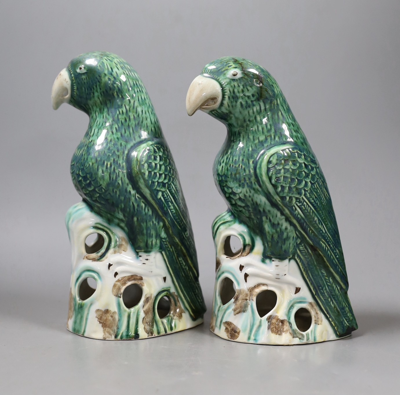A pair of Asprey marked ceramic parrots on perches made for Recollections Ltd. by Gladstone Pottery Museum. 23cm high